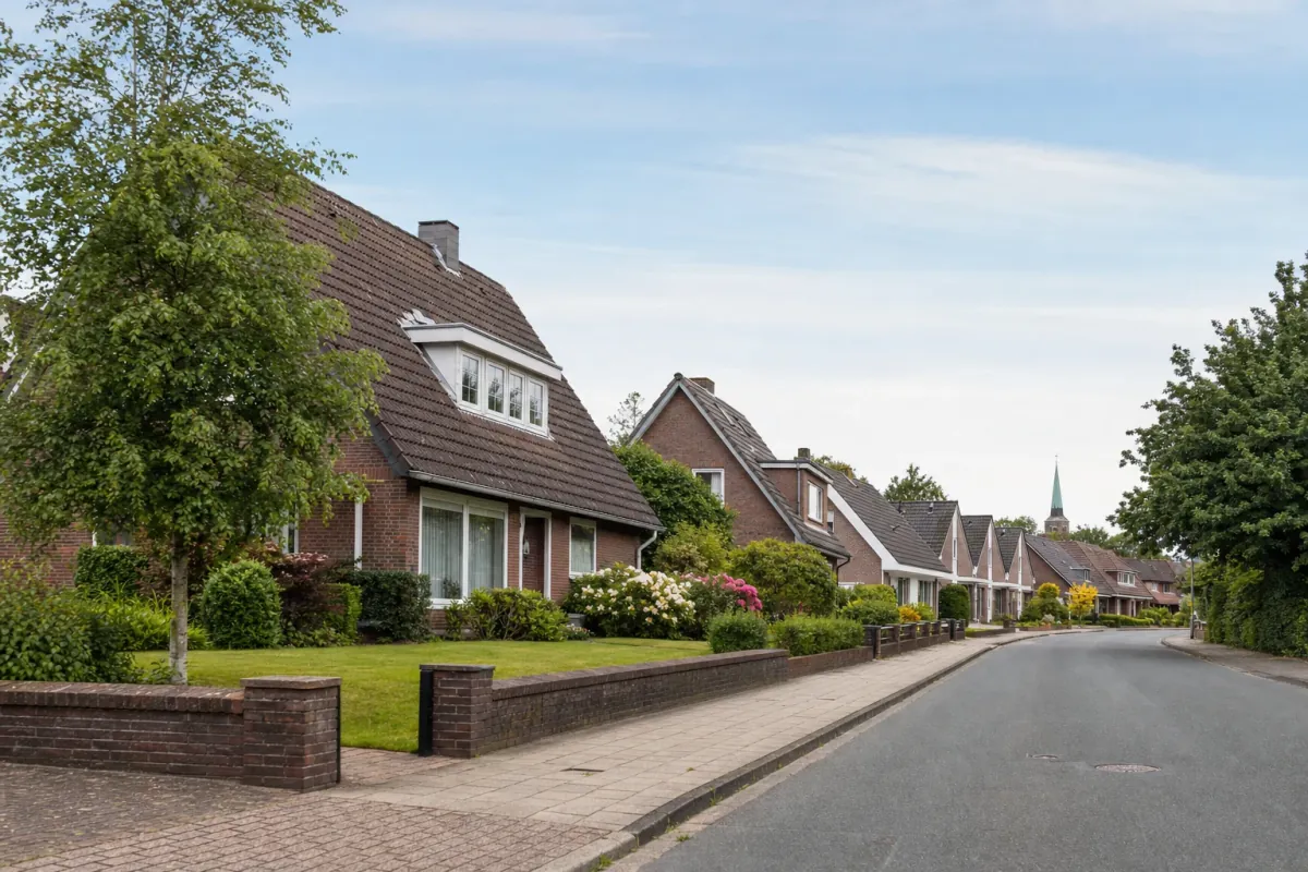 Wohnstraße in Oldenburg: die für die Stadt typische Bebauung, im Hintergrund über den Dächern ein Wahrzeichen der Stadt.