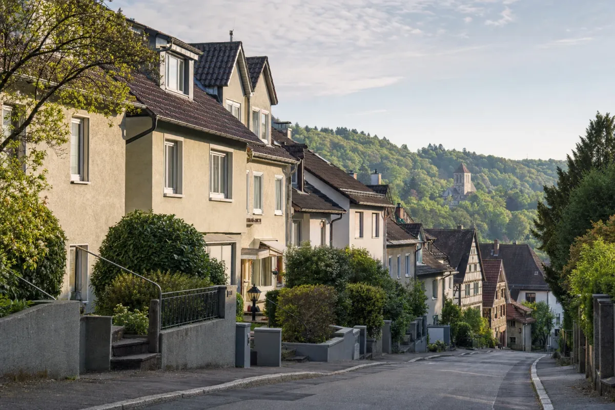 Wohnstraße in Tübingen: die für die Stadt typische Bebauung, im Hintergrund über den Dächern ein Wahrzeichen der Stadt.
